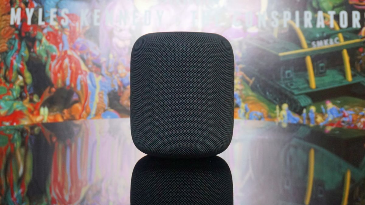 The HomePod in front of trippy background art made up of swirling shapes and colors