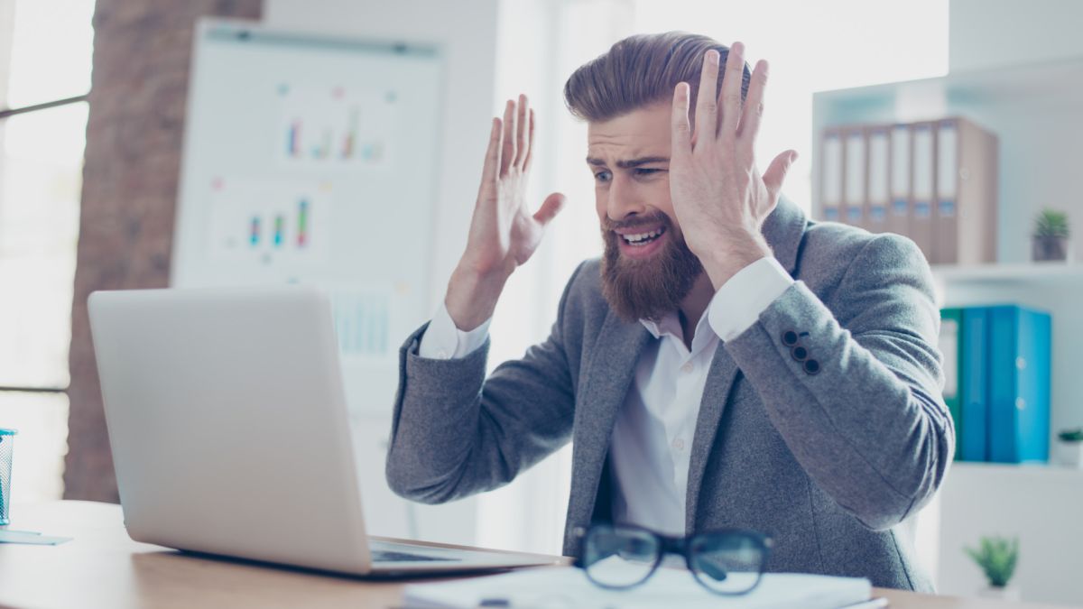 Stressed out businessman looking at laptop