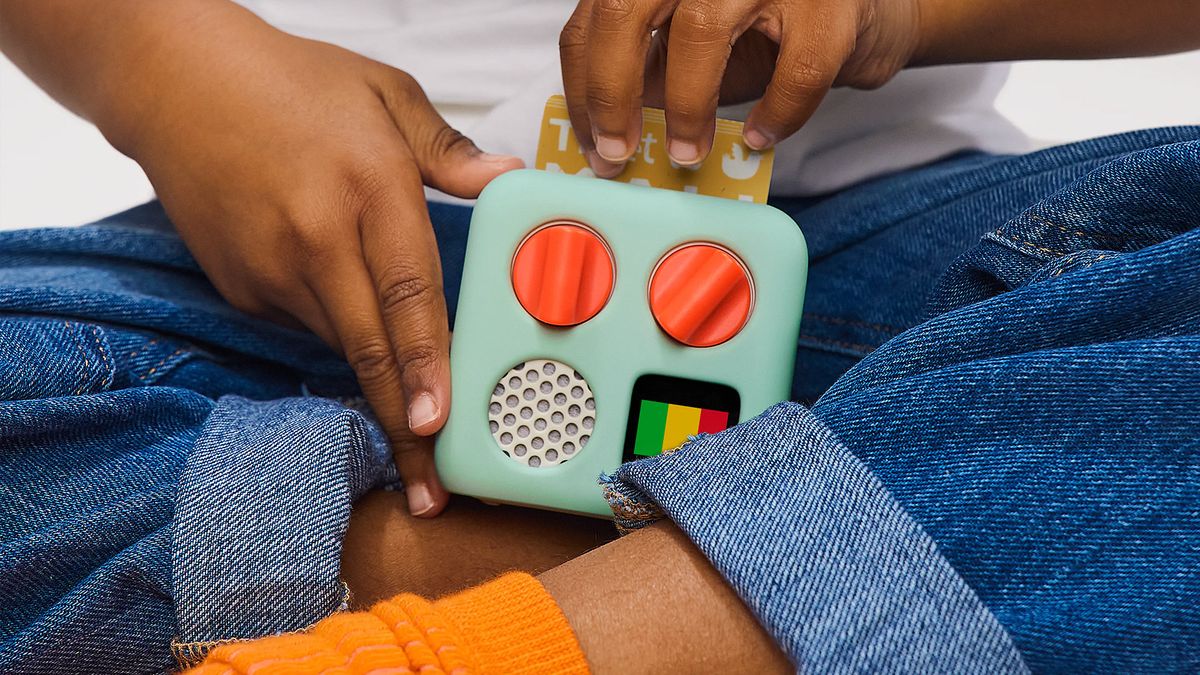 A kid holds the Yoto Mini speaker