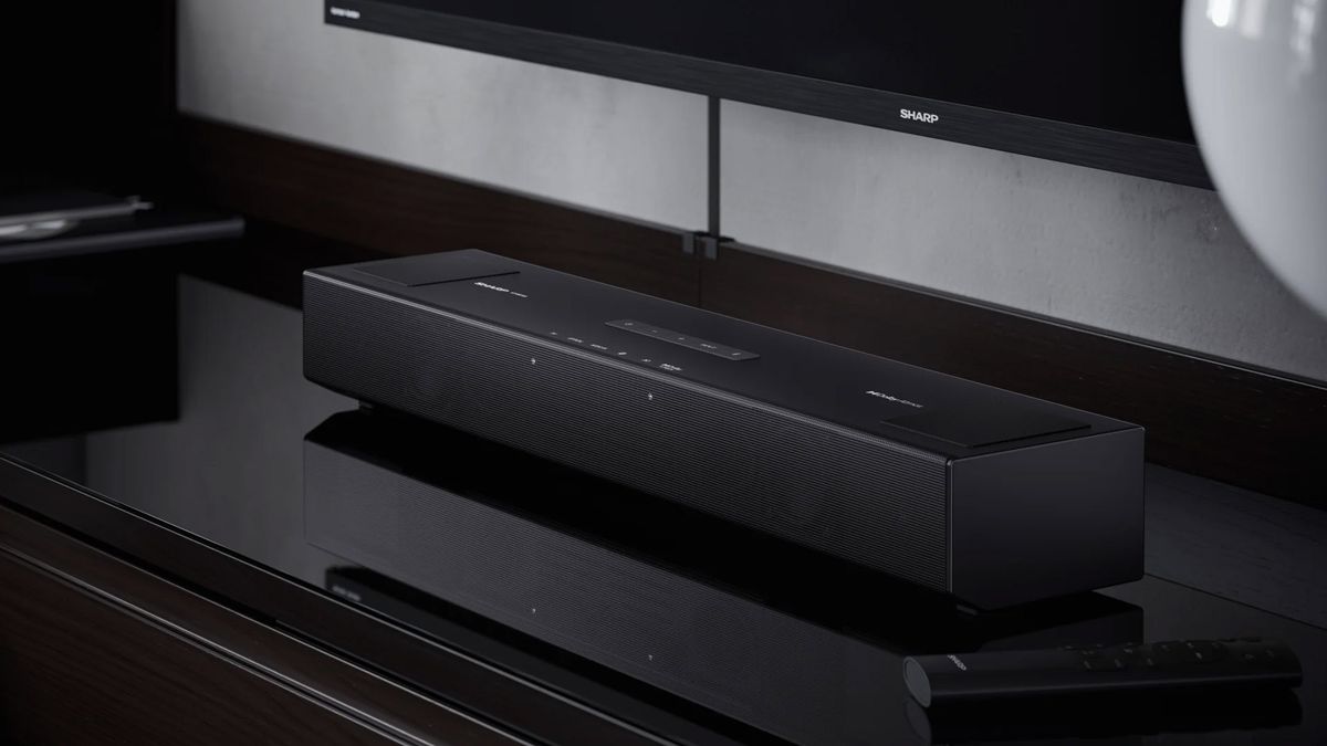 A Sharp soundbar sits in front a Sharp TV